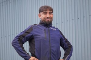 Porträtfoto - Abdul in dunkelblauer Firmen-Softshell-Jacke