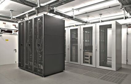 Ein Serverraum, in dem viele Schränke stehen in denen viele Server angeschlossen und verkabelt sind.